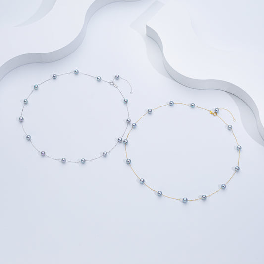 Two Akoya Sea Pearl necklaces, one with the pearls strung on a gold chain and another with the pearls in a silver-tone setting, displayed against a white background.