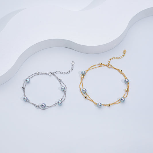 Two Akoya sea pearl double layer bracelets, one with silver color and the other with gold color, displayed on a white surface.