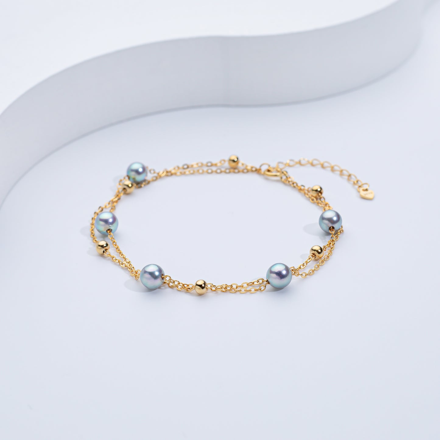 A two-layered Akoya sea pearl bracelet with silver and gold-colored elements, displayed against a white background.