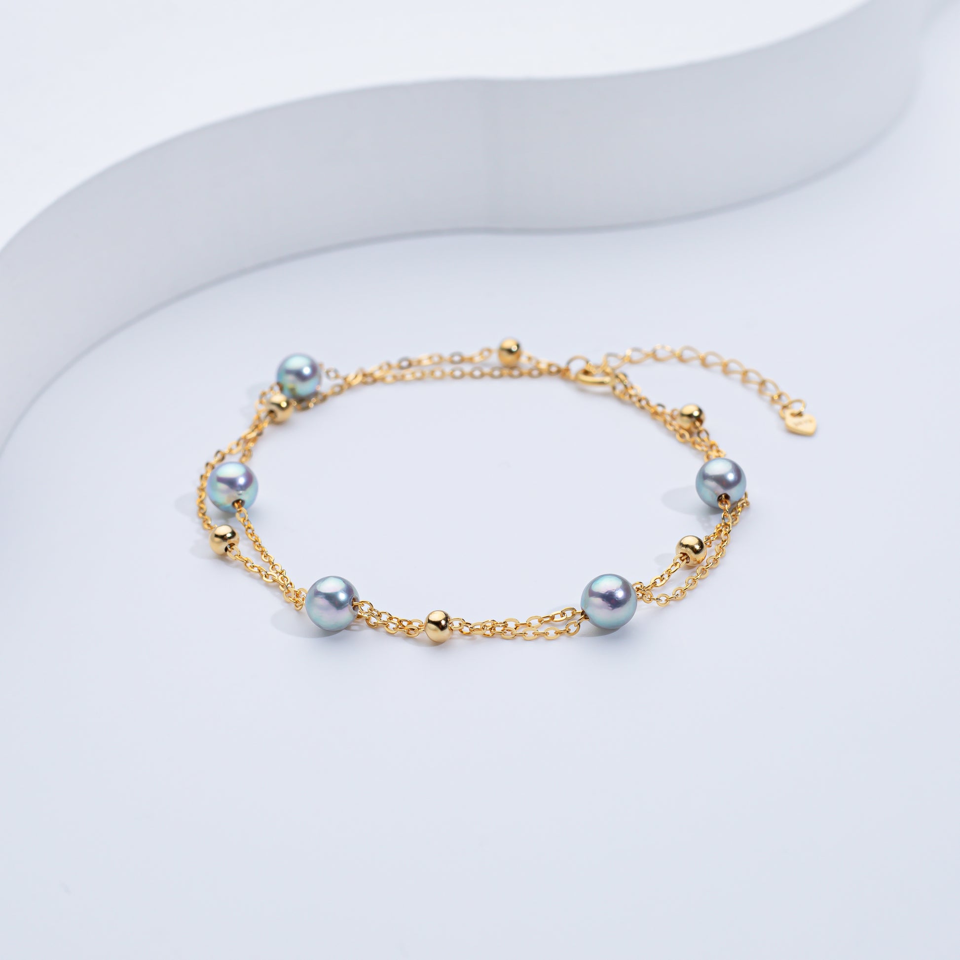 A two-layered Akoya sea pearl bracelet with silver and gold-colored elements, displayed against a white background.