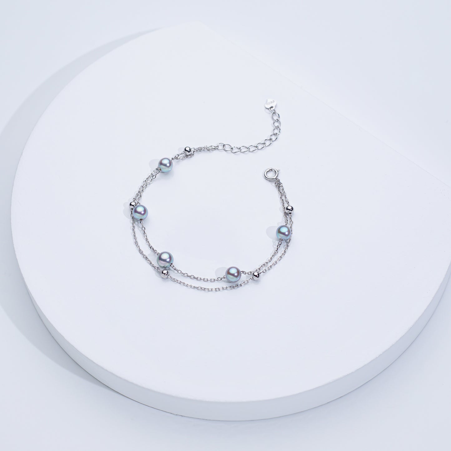 Two Akoya sea pearl double layer bracelets, one with silver color and the other with gold color, displayed on a white surface.