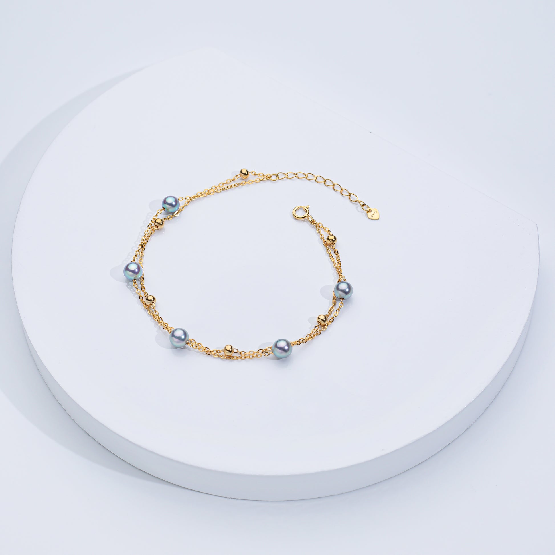 Two Akoya sea pearl double layer bracelets, one with silver color and the other with gold color, displayed on a white surface.